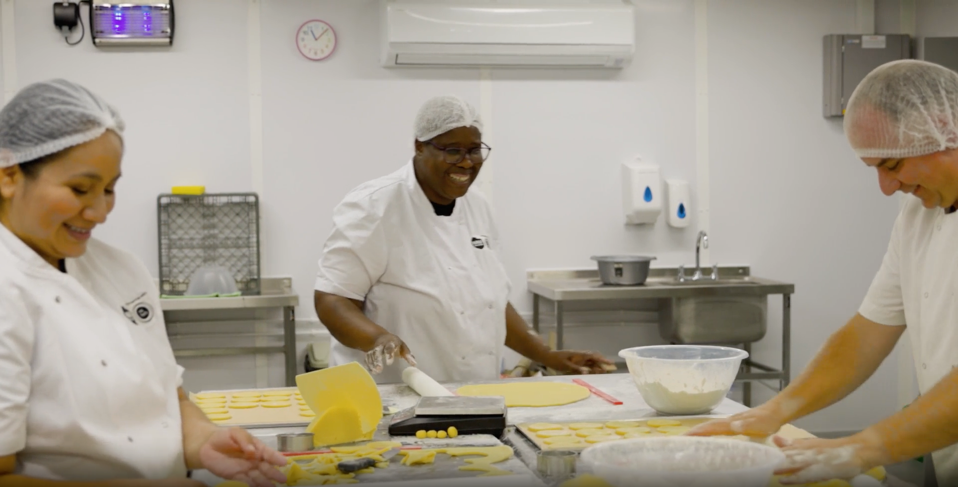 Smiling bakers working in the Half the Story bakery.