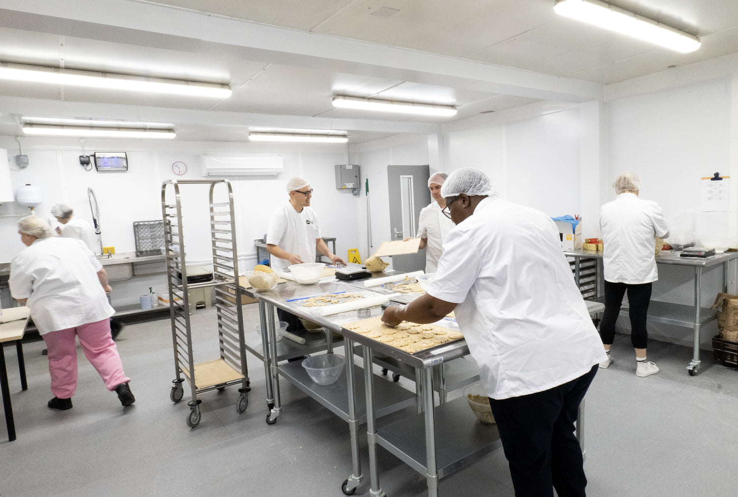 Half the Story Bakery kitchen with workers preparing handmade biscuits.
