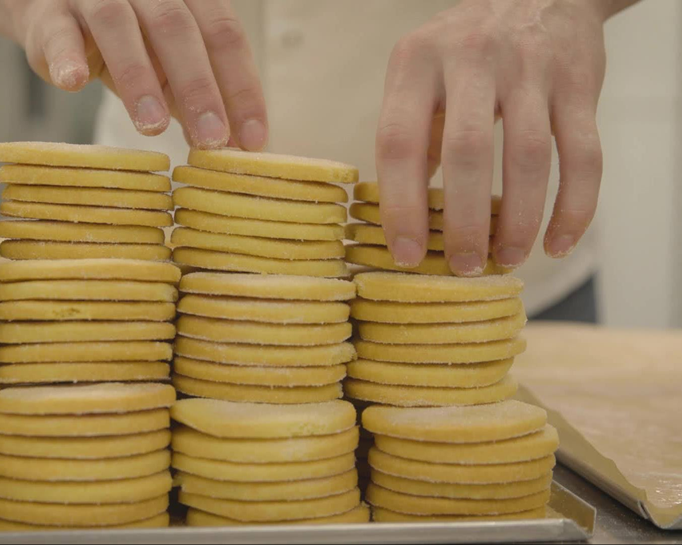 Hands arranging Half the Story shortbread biscuits.